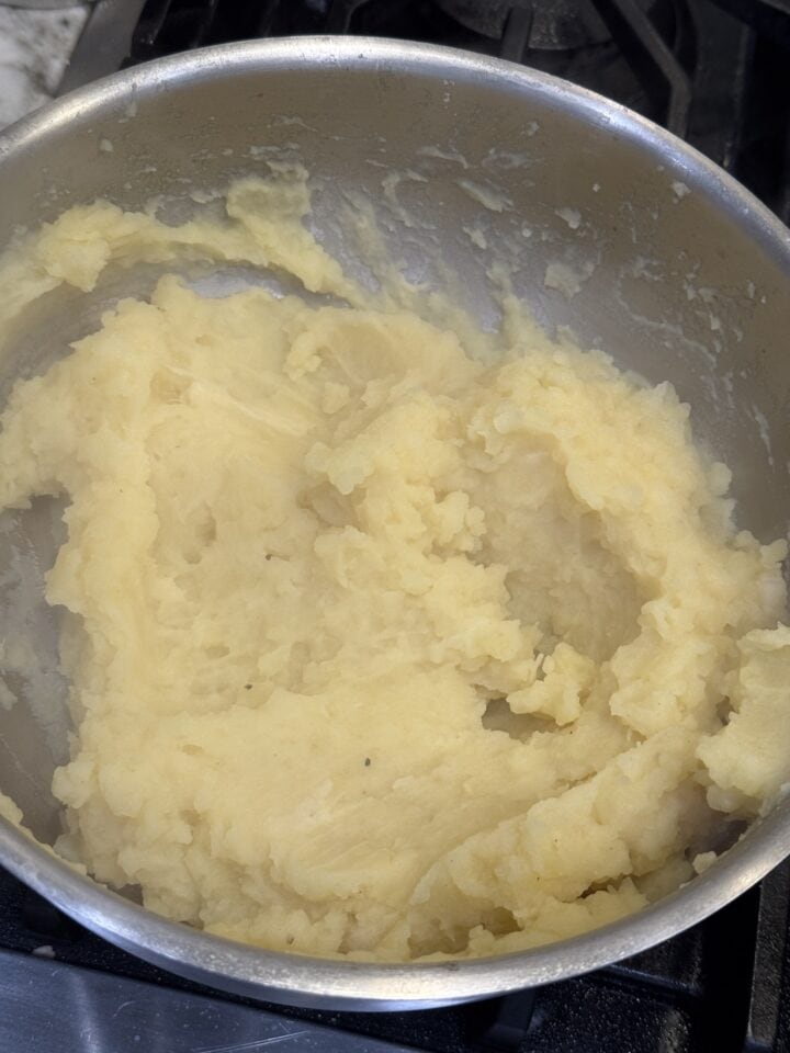 Creamy mashed potatoes in a silver pot for comfort food recipes.