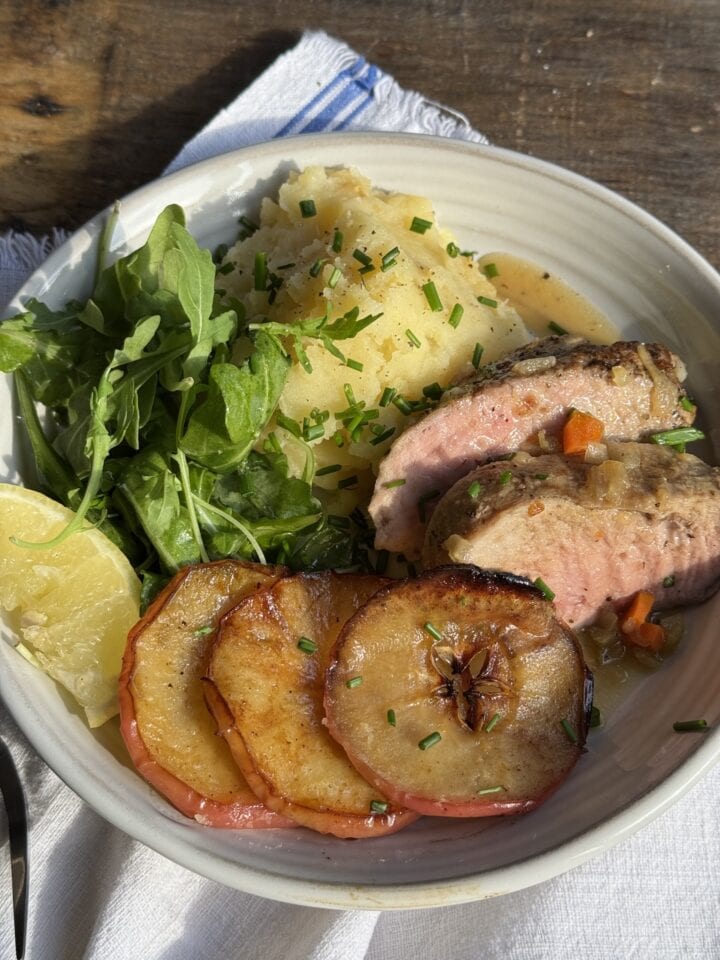 a photo of a plated serving of roast pork loin apples and potato parsnip puree