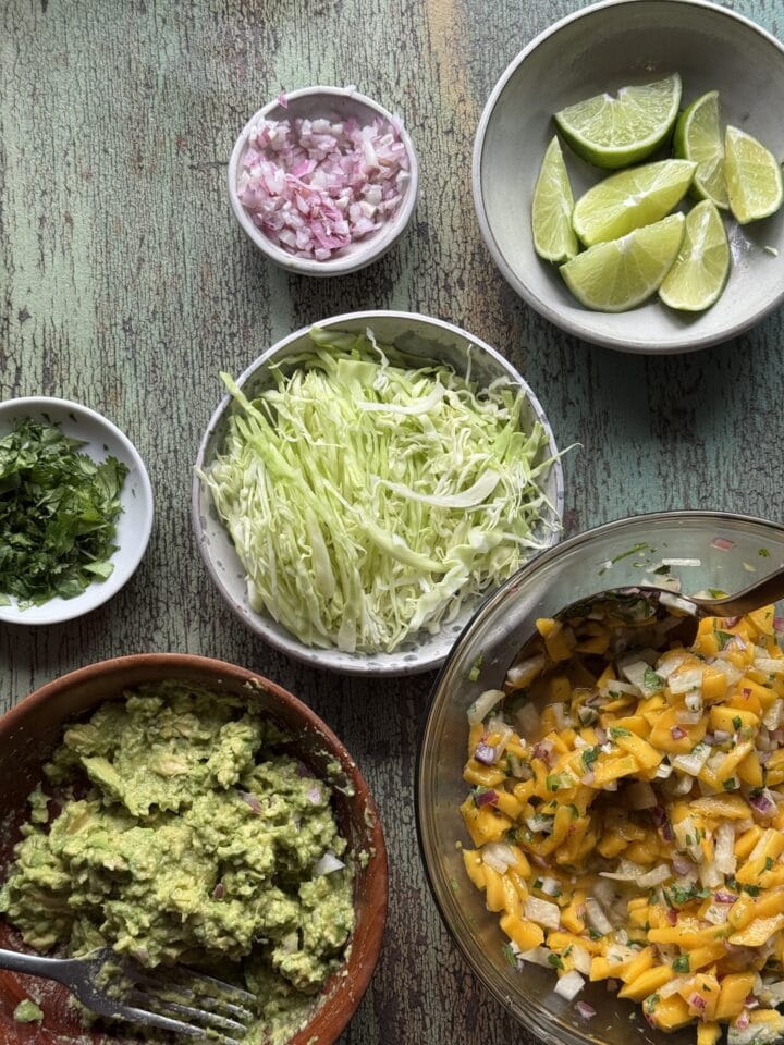 ingredients for fish taco toppings in small bowls