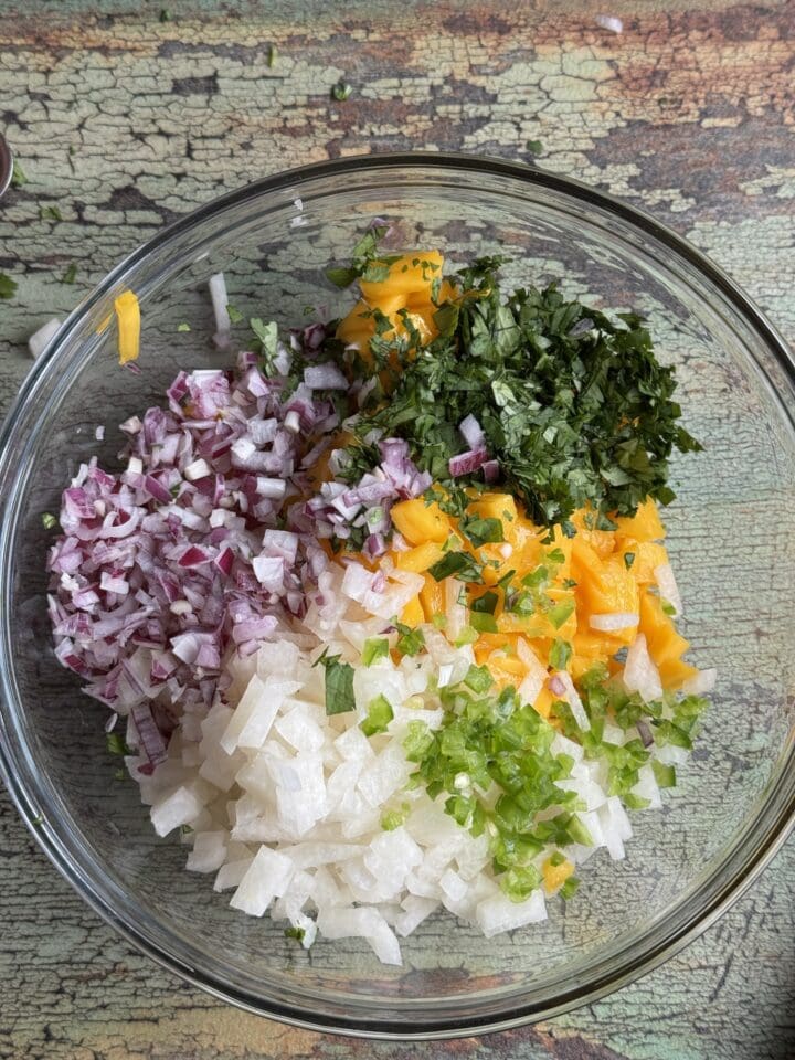 chopped mango salsa ingredients in a glass bowl