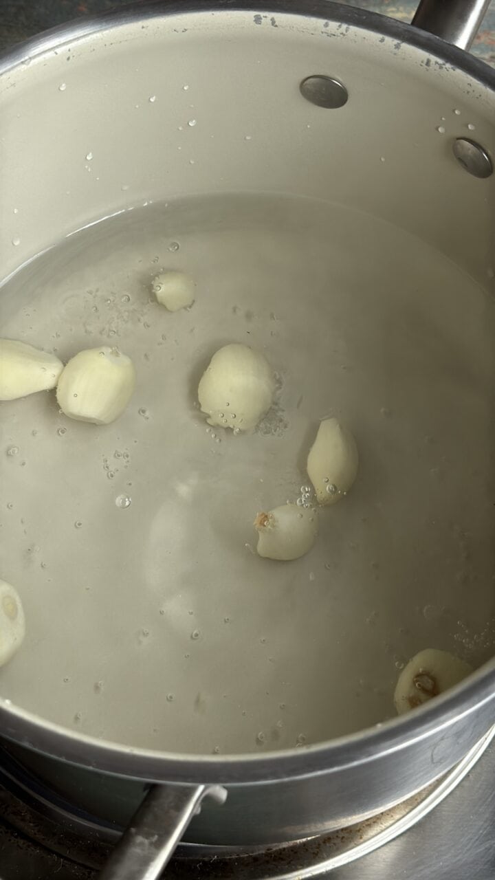 garlic simmering in a pot of water