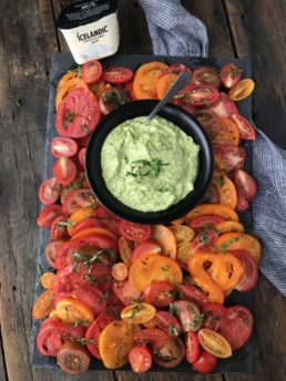 A platter of tomatoes with pesto skyr