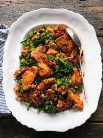 Chicken and broccolini stir fry in a white platter