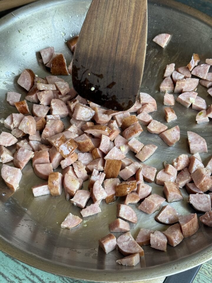 cubed sausage in a stainless steel pan
