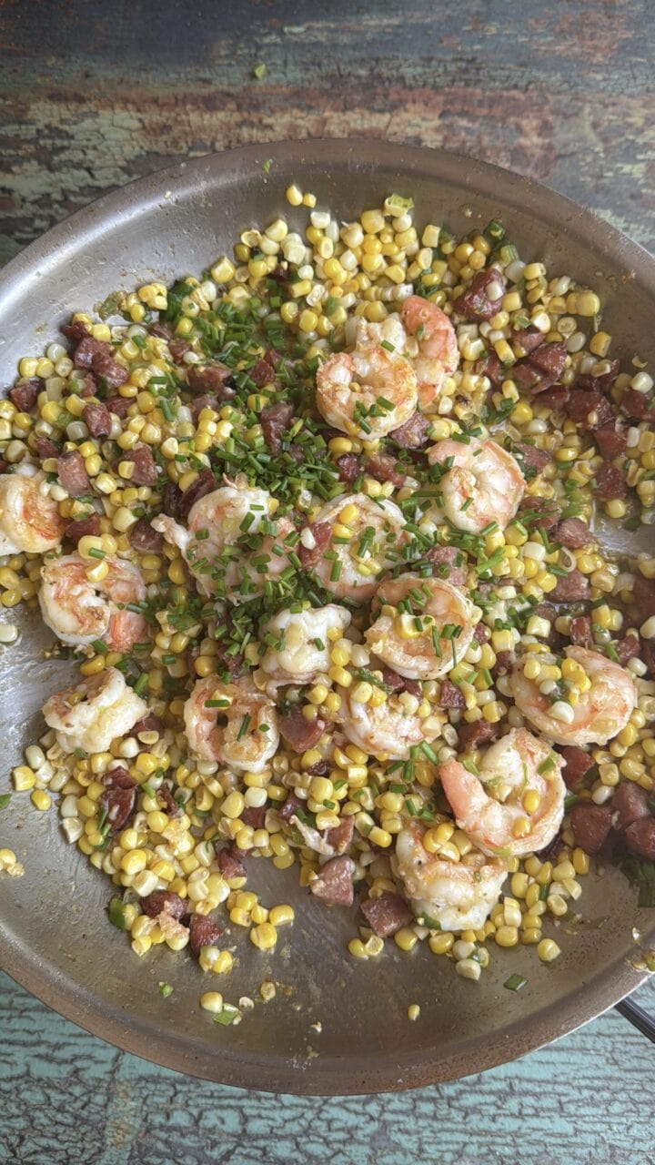 shrimp and chorizo with corn saute in a stainless steel pan