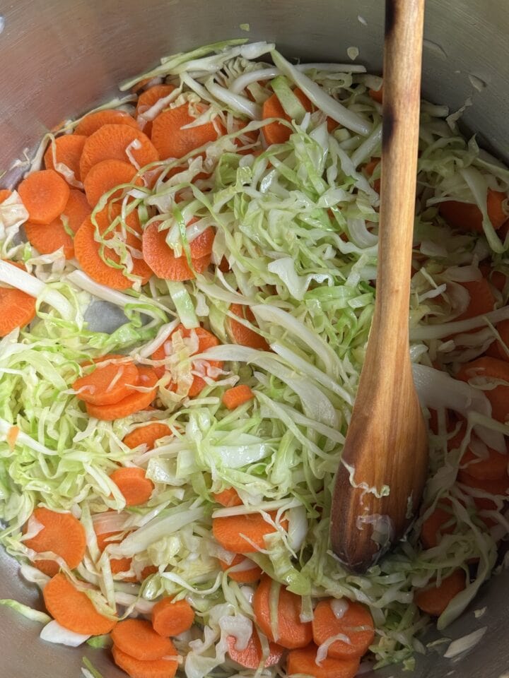 a photo of carrots and cabbage cooking in a pot