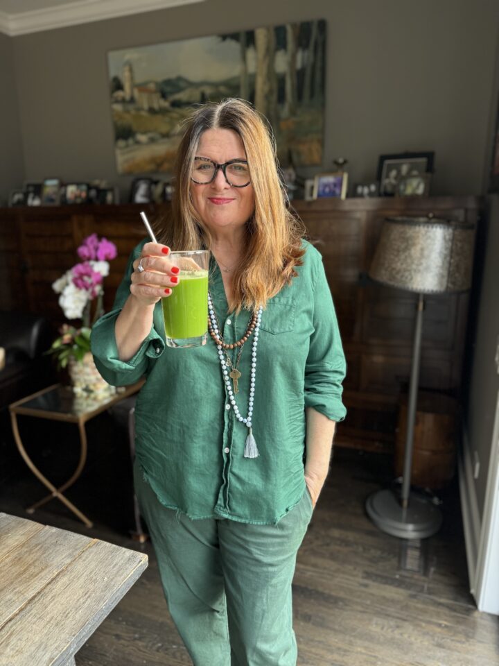 Teri wearing all green while drinking a green juice