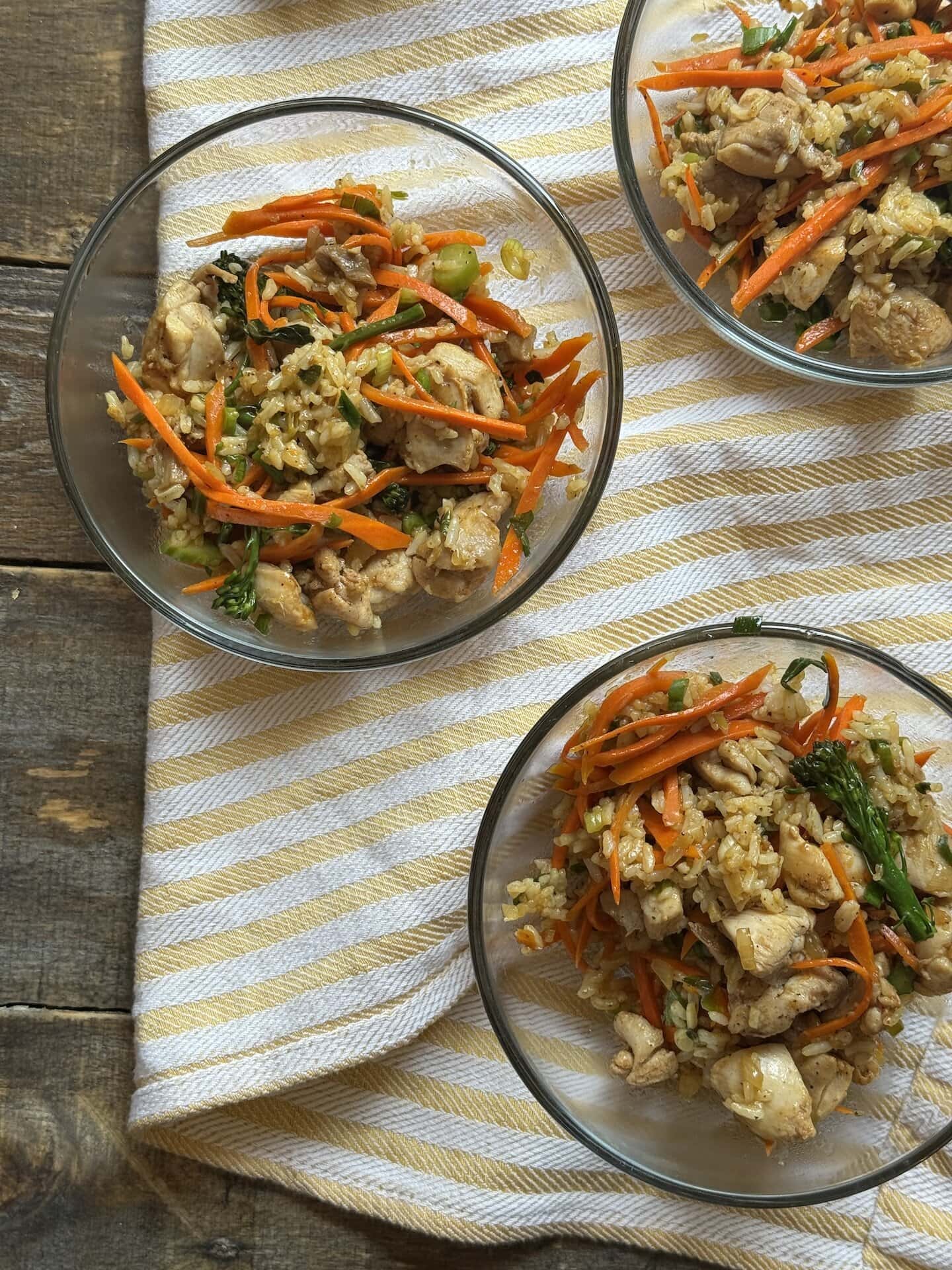 a photo of three bowls of chicken fried rice