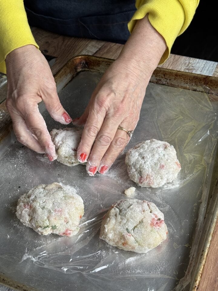 four white fish cake patties on a baking sheet