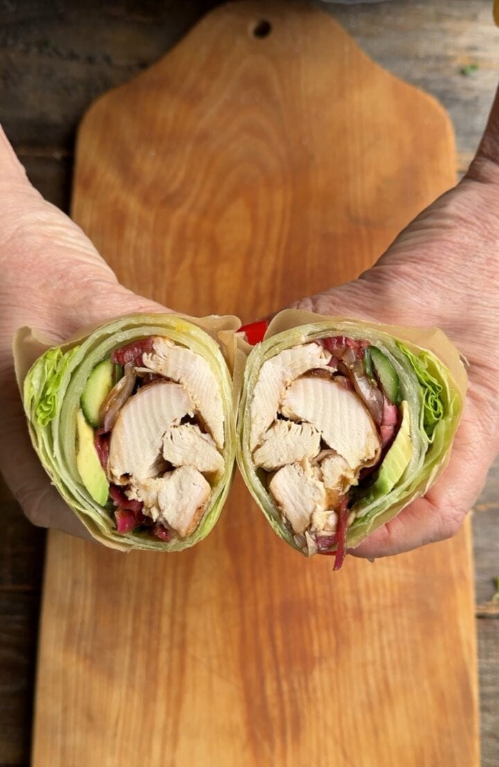 teri holding to halves of a bangkok chicken lettuce wrap in her hands