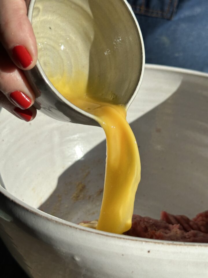 pouring melted butter into meat