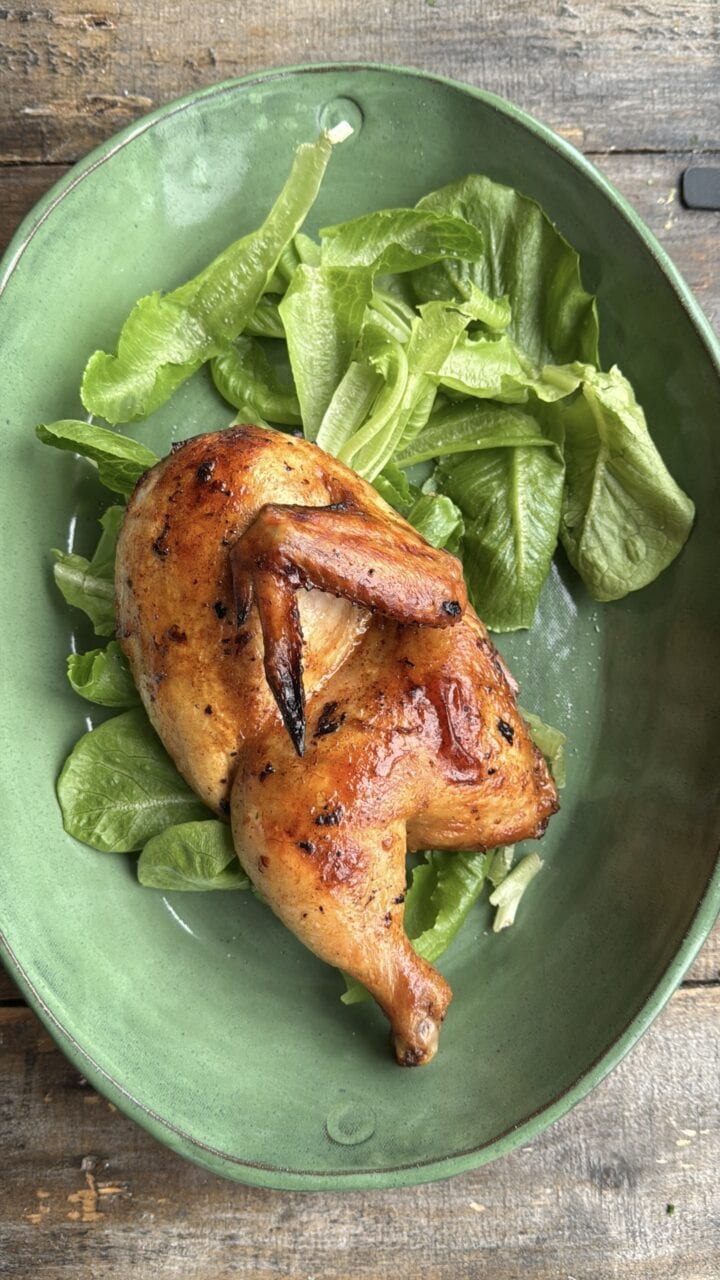 chicken half on a bed of greens