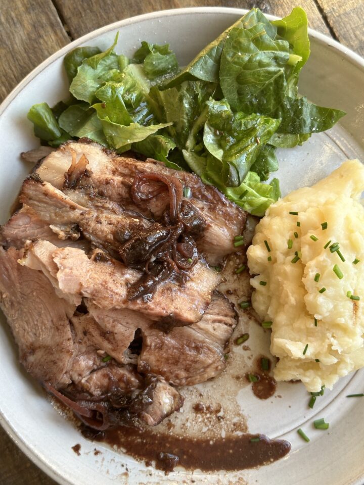 plated pork roast with mashed potatoes & greens