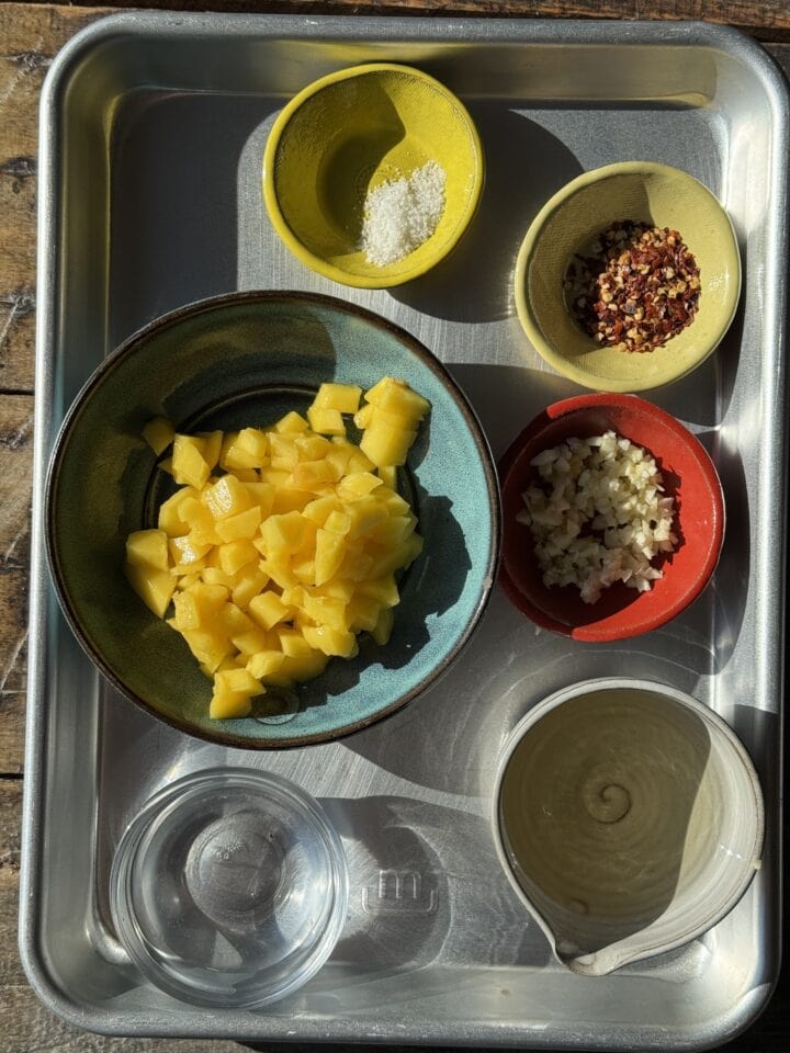 the ingredients for mango chili sauce on a sheet pan