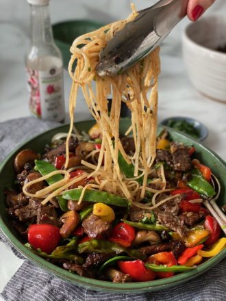 rice noodles over beef stir fry in a jade roy bowl