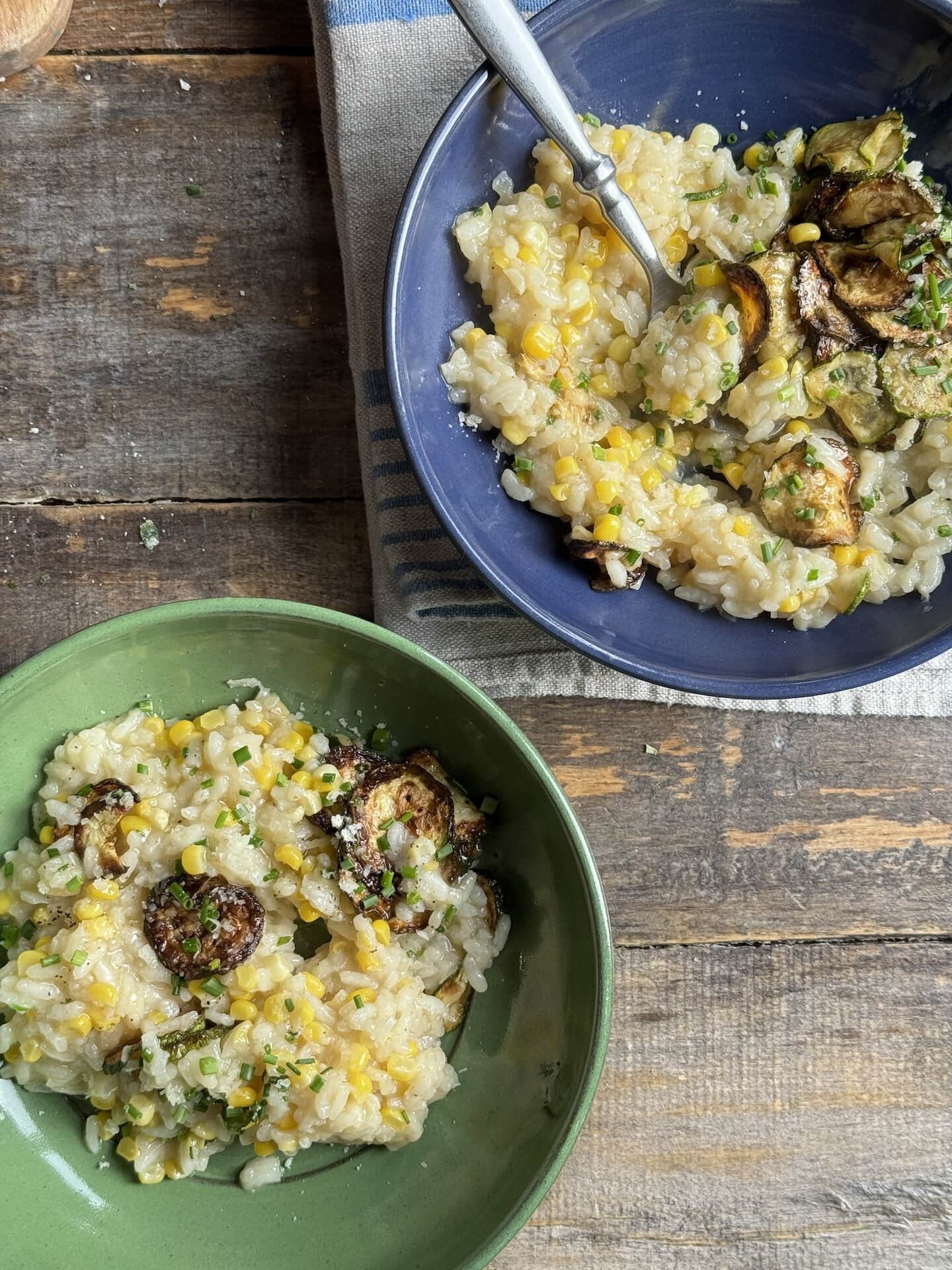a photo of summer risotto in green and blue bowls