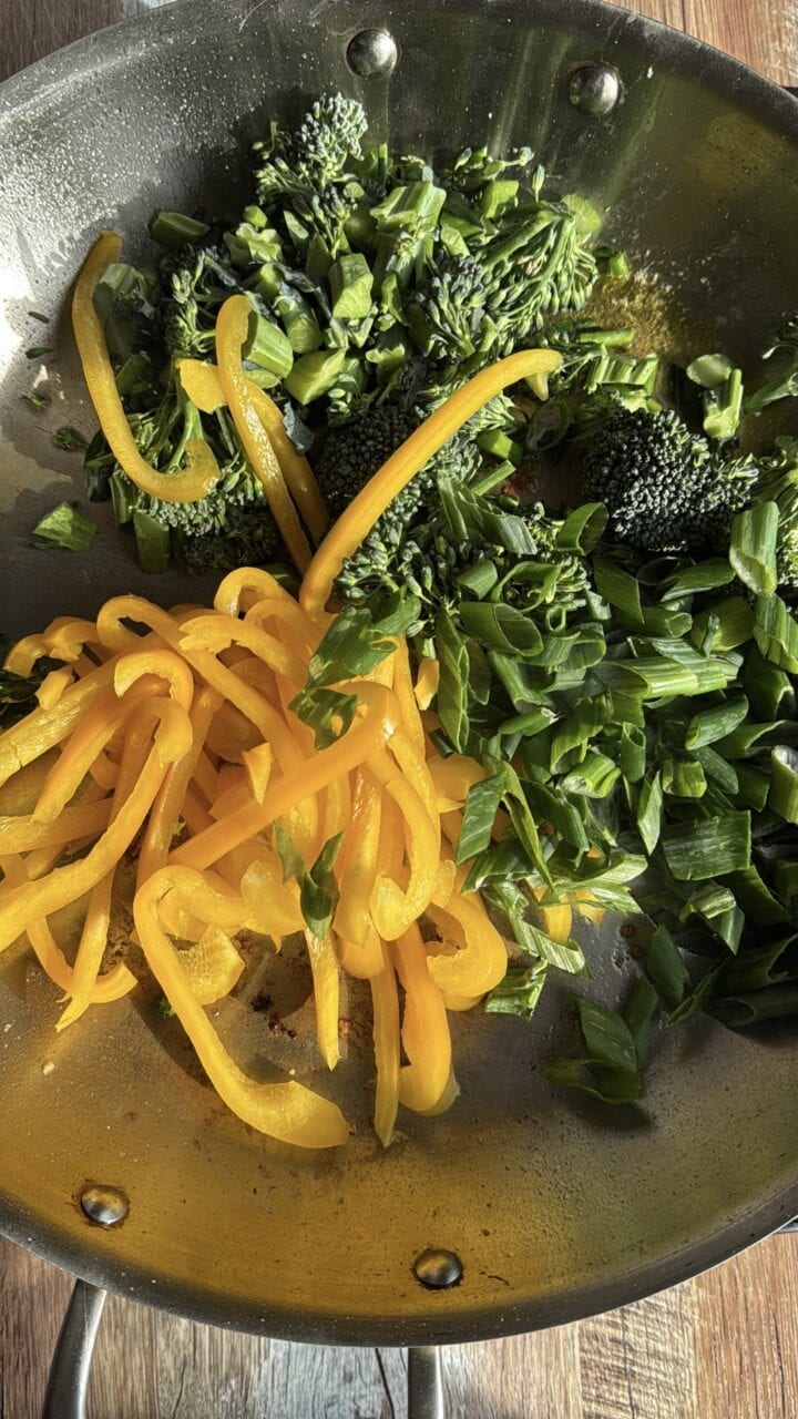 broccolini and yellow bell pepper slices in a pan