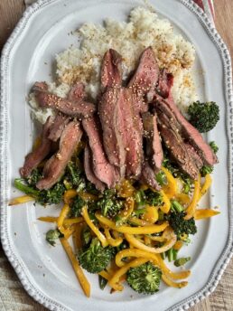 stir fry with beef on a white platter with rice