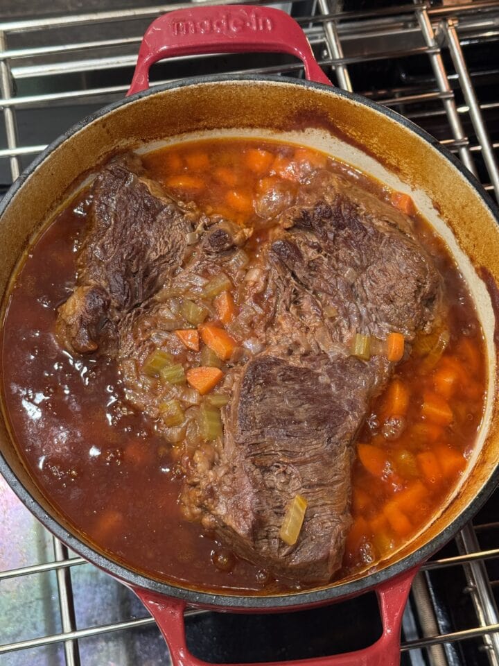 cooked pot roast and vegetables in a dutch oven