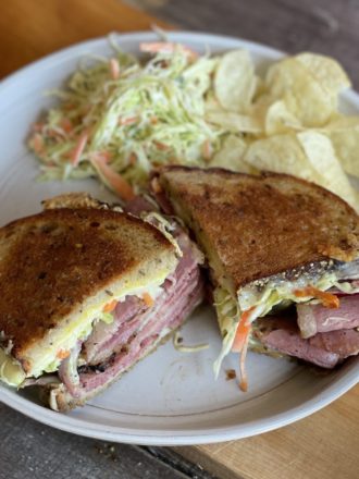 pastrami sandwich with coleslaw and chips