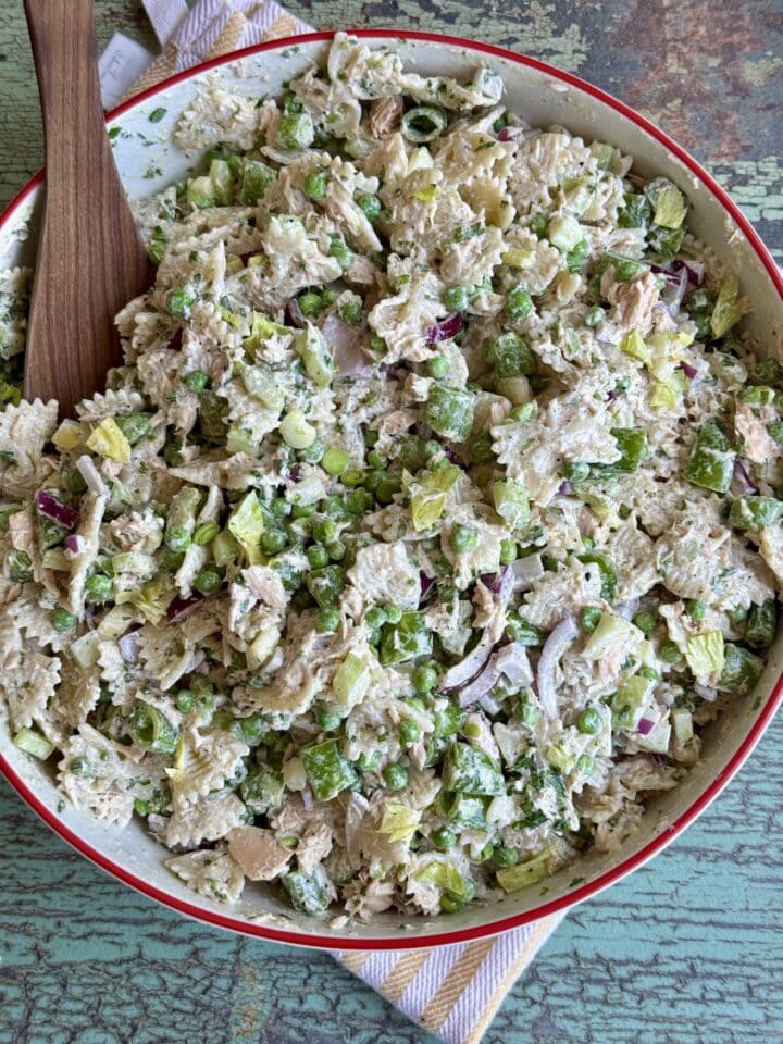 tuna pasta salad in a serving bowl with a wooden spoon in it