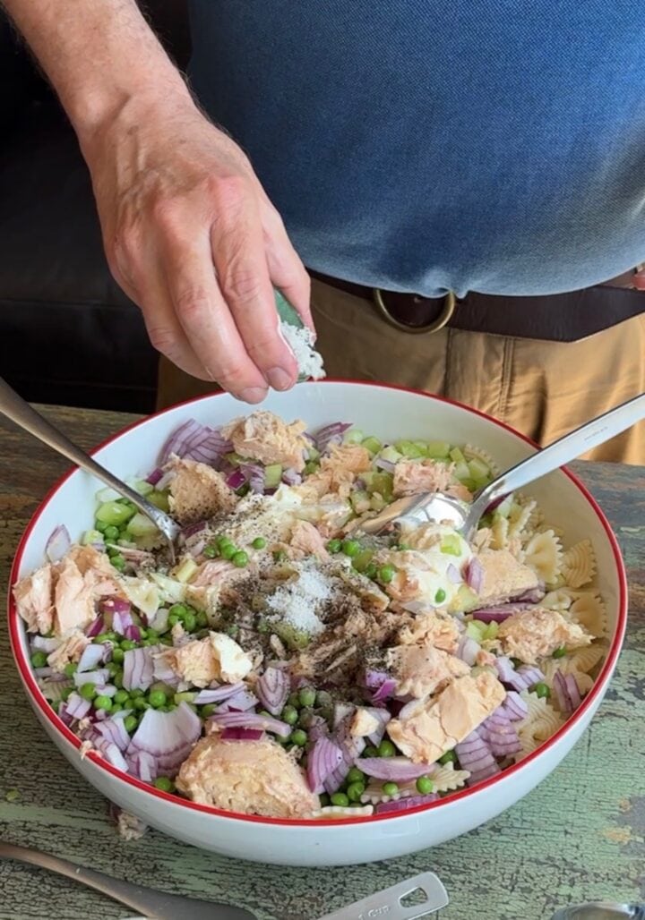 seasoning tuna pasta salad with salt and pepper