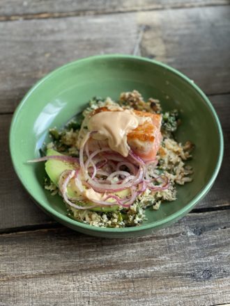 close up on salmon rice with avocado and marinated onions