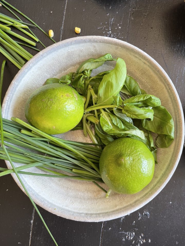 lime, chives, and basil in a bowl
