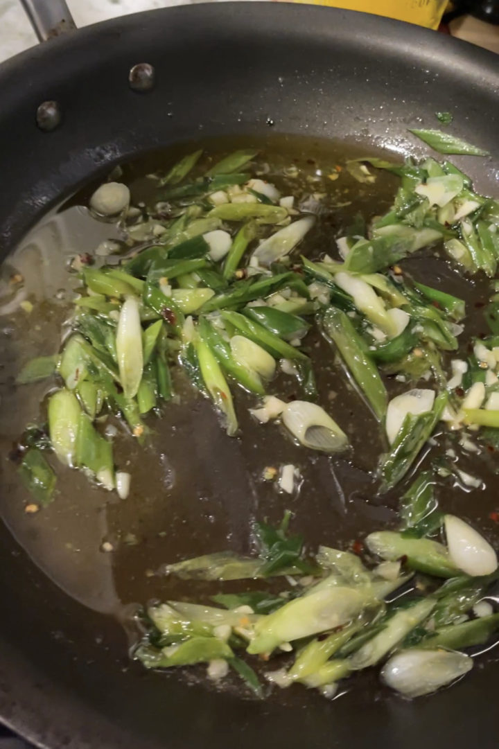 green onions and garlic in a pan