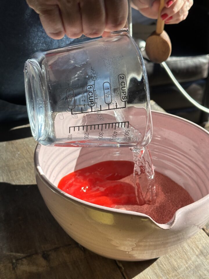 pouring water into bowl with jello powder