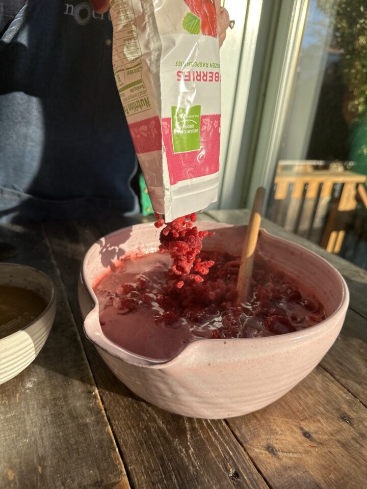 adding frozen raspberries into bowl