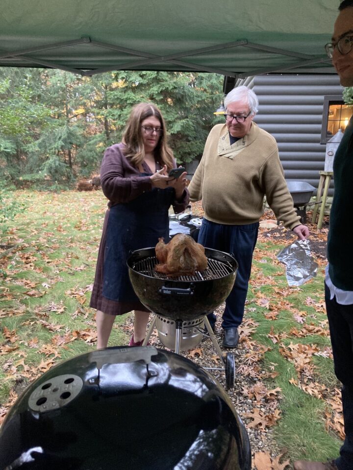Teri & Roy looking at turkey on grill