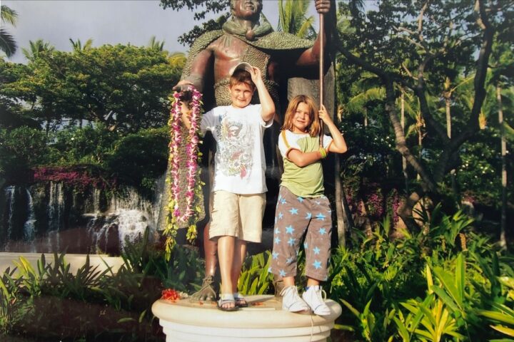 two kids infront of a statue