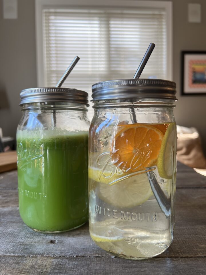 green juice & water with fruit slices in it on a counter