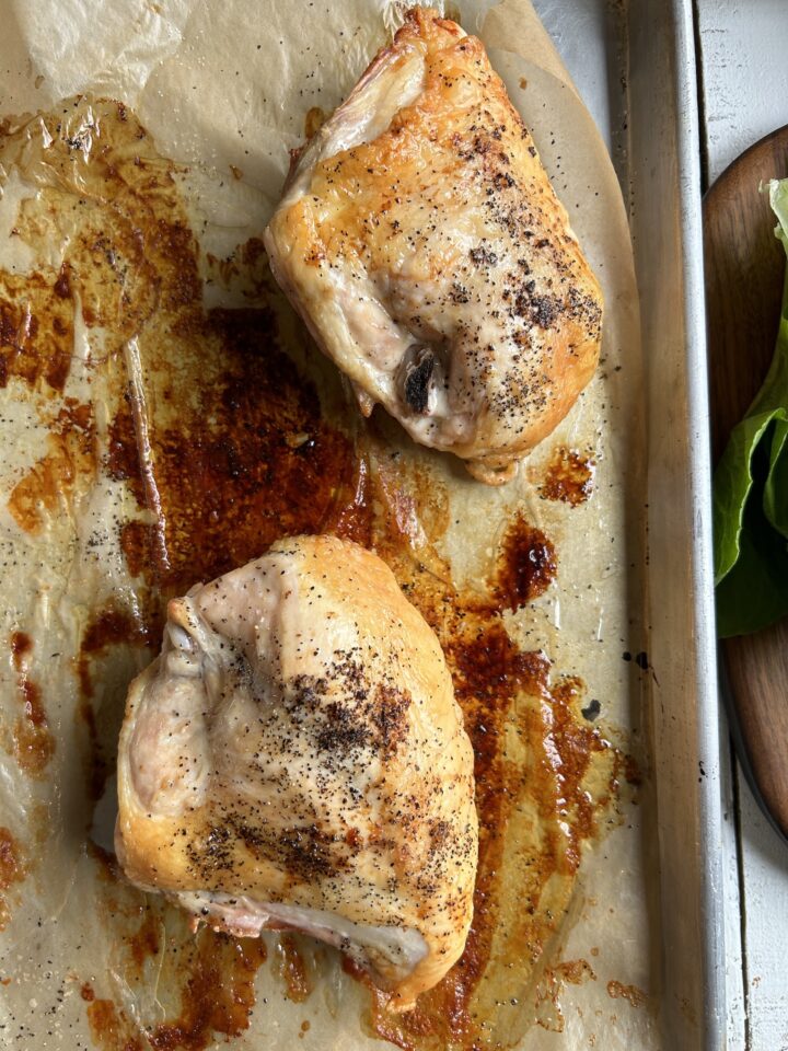 roasted chicken on a pan with parchment paper