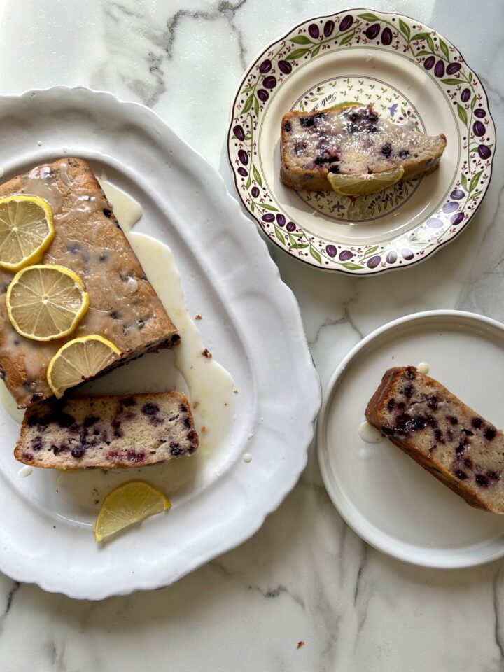 lemon blueberry cake on a platter and two cake slices next to it