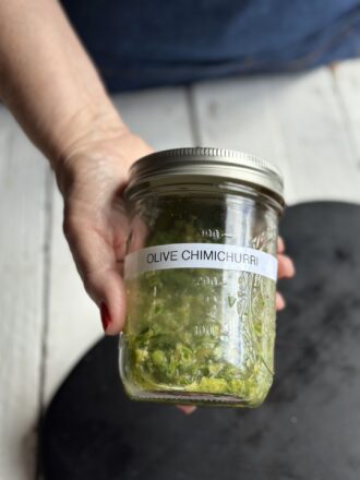hand holing jar labeled olive chimichurri