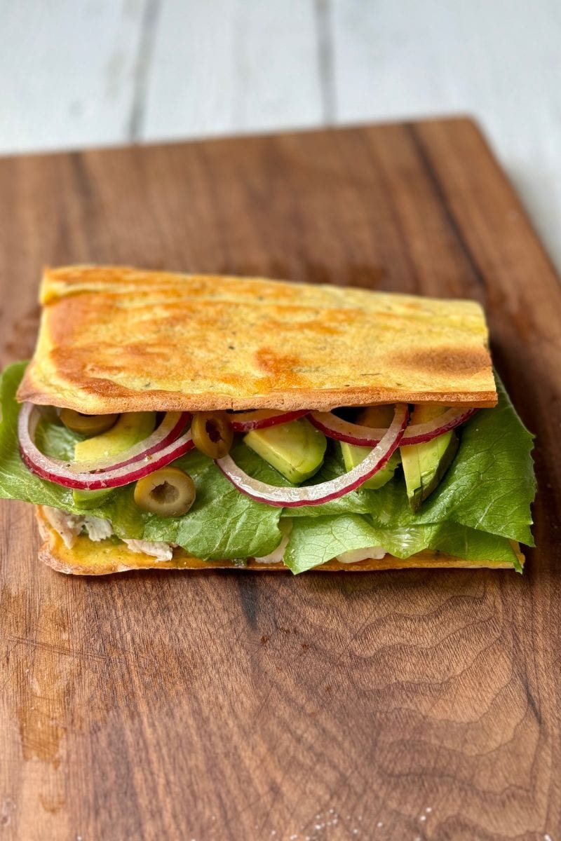 close up shot of a finished cottage cheese wrap on a wooden cutting board