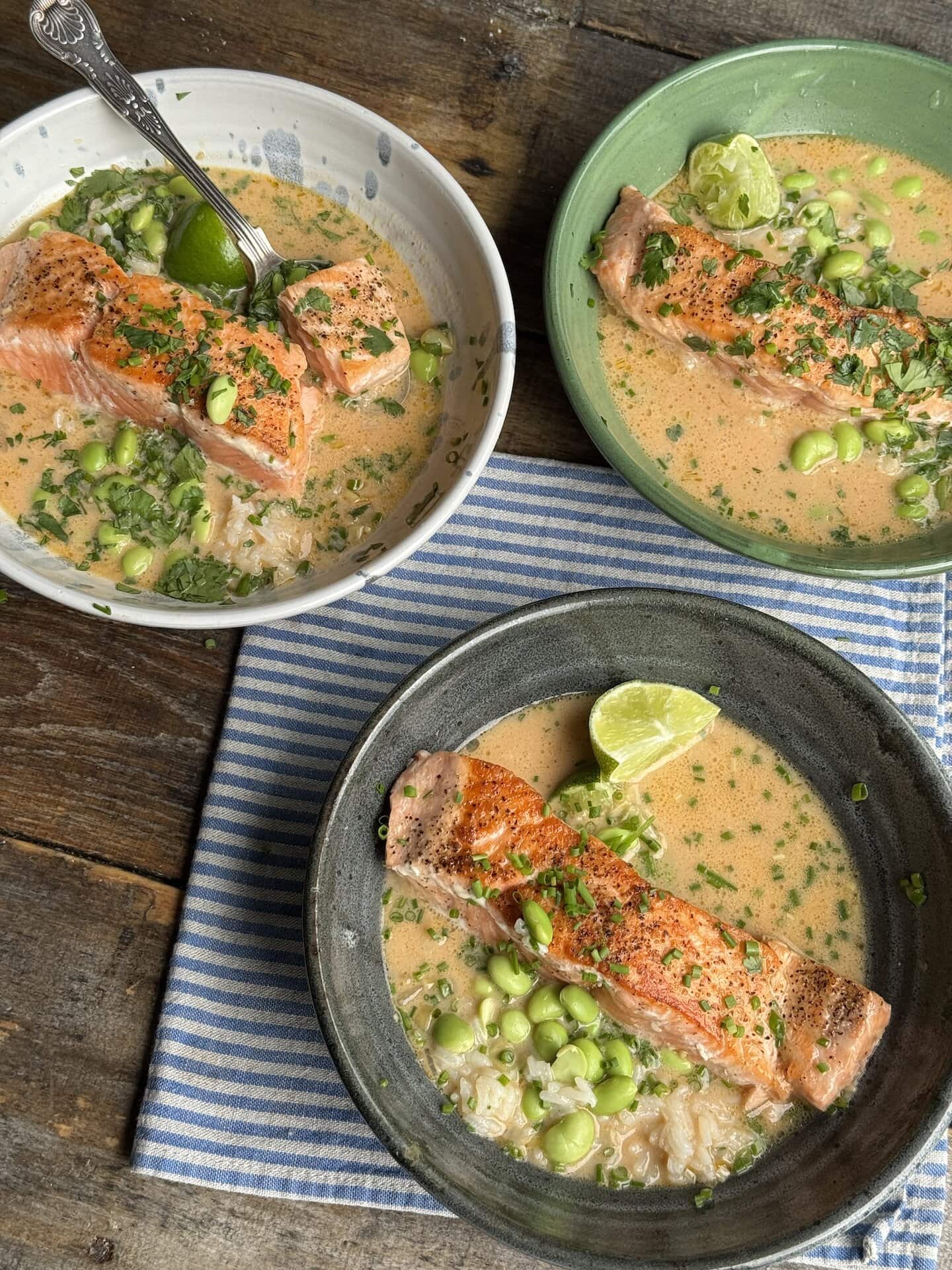 three bowls of salmon with coconut curry broth