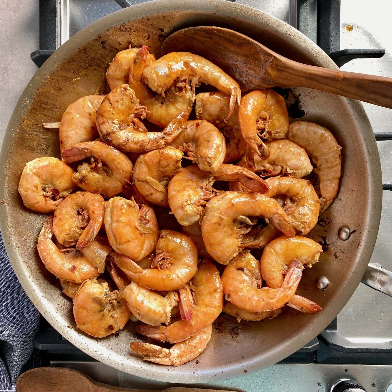 glazed cooked shrimp in a stainless steel pan