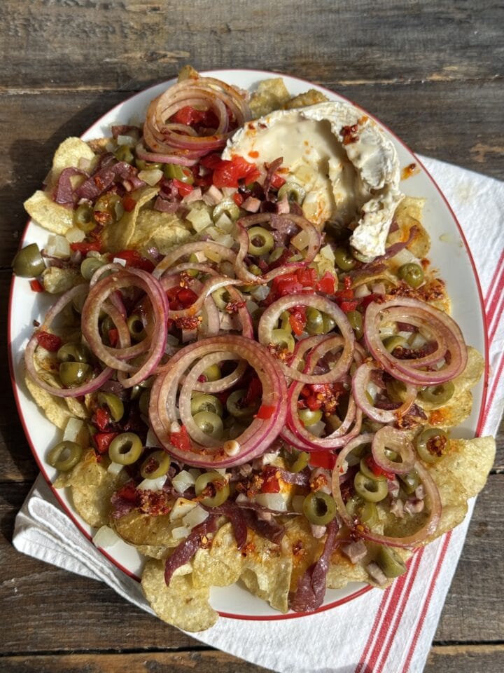 a photo of loaded potato chip nachos on a white platter
