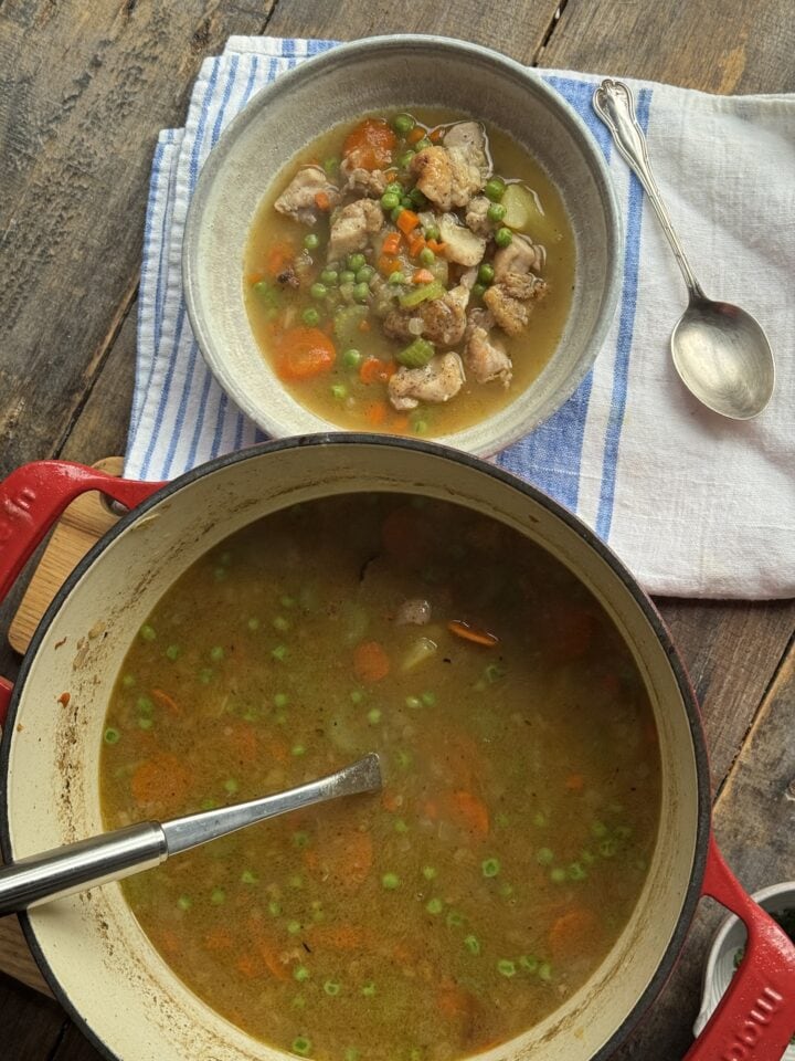 a bowl of soup next to a pot of soup