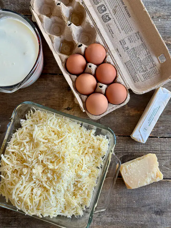 the ingredients for cheese souffle spread out on a wooden surface