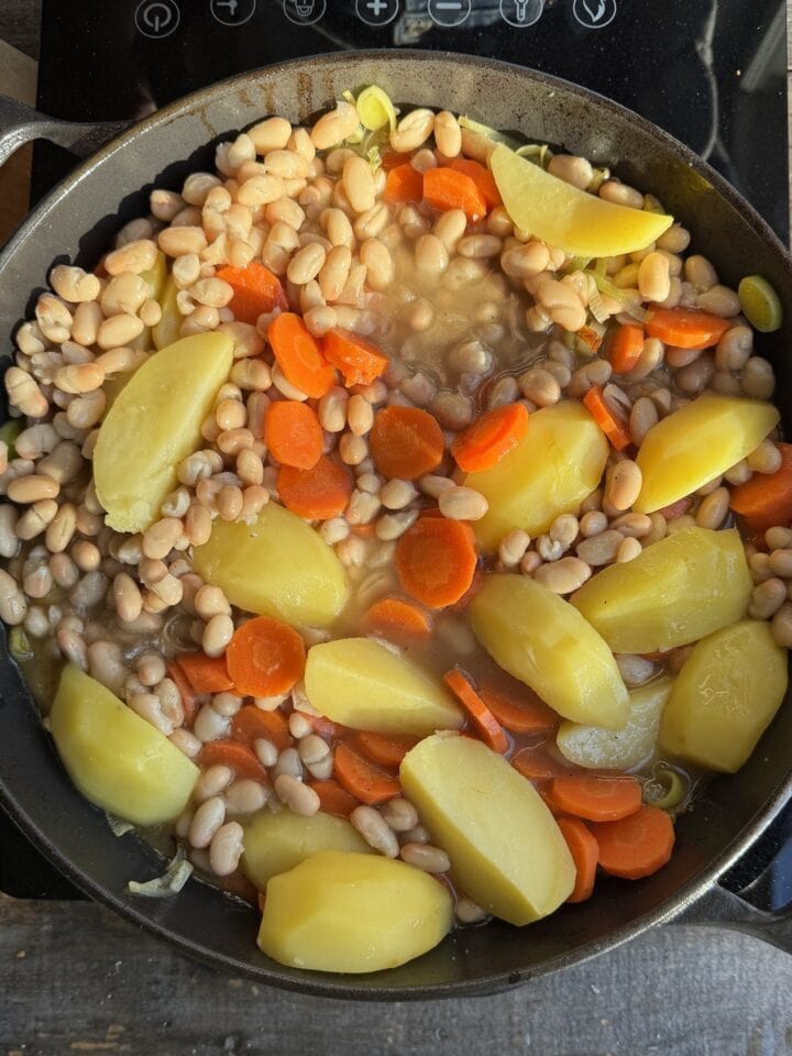 beans, carrots and potatoes in a cast iron skillet