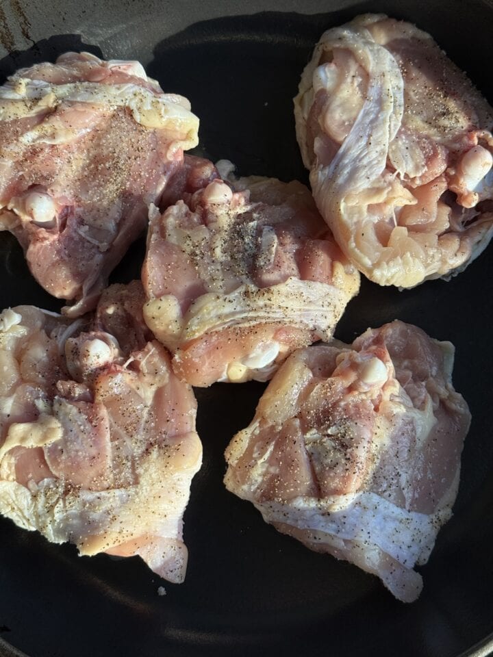 chicken thighs skin side down in a cast iron skillet
