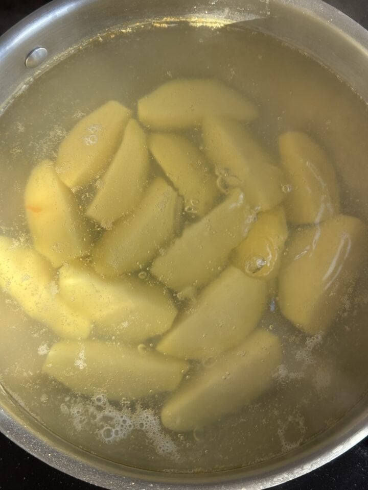 potato wedges boiling in a pan