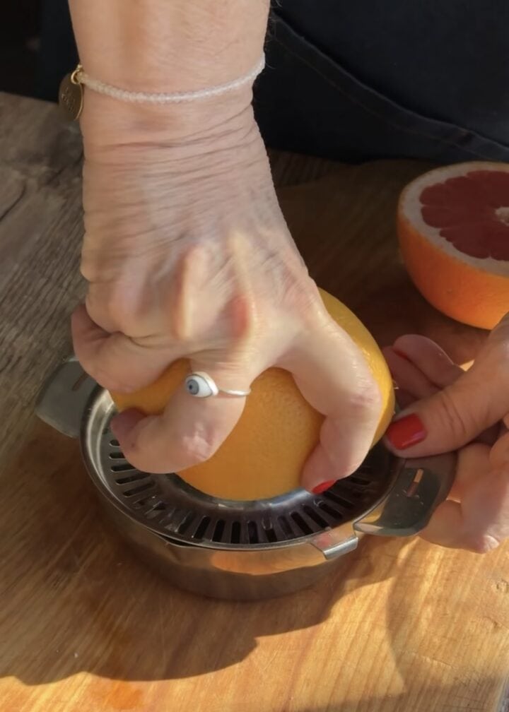 hand with ring juice a grapefruit half
