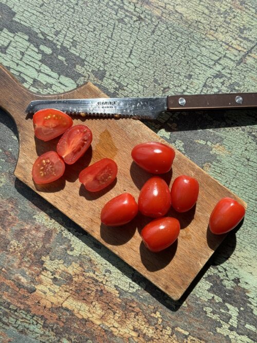 sliced tomatoes on a wooden cutting board
