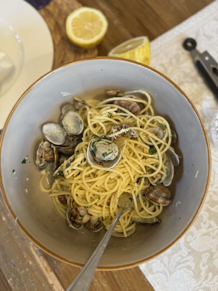 clam pasta in a blue bowl on a table