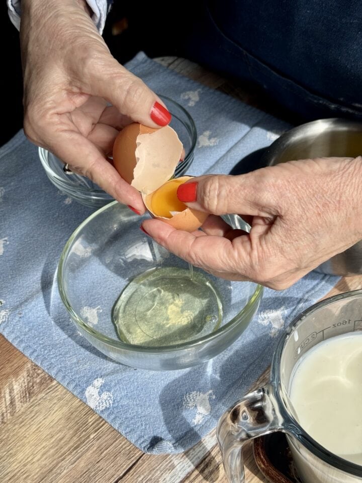 teri separating egg yolk from egg white over a glass bowl